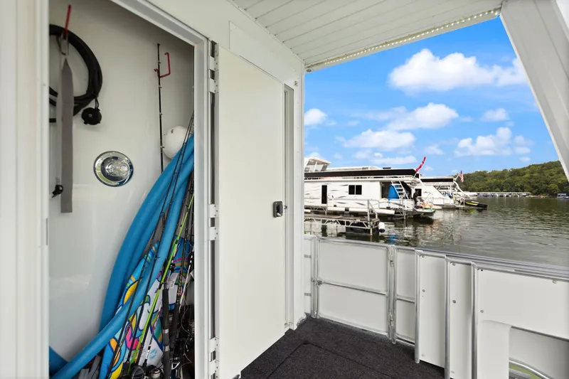 Slide: The Image of Houseboat deck with water sports gear, overlooking a serene lake and other houseboats. - 26