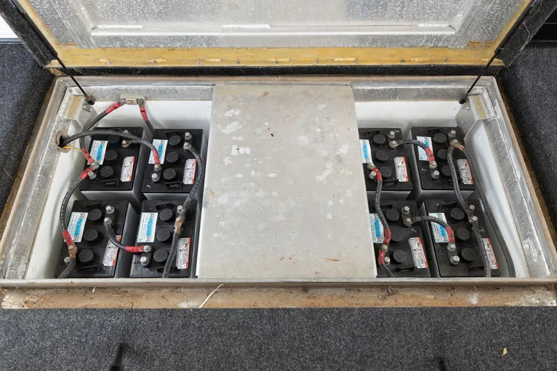 Slide: The Image of Battery compartment of a 2001 Stardust Cruisers 18 x 100 houseboat, showing multiple batteries. - 27