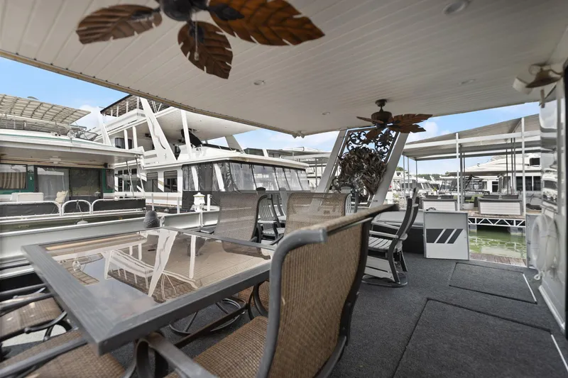 Slide: The Image of Outdoor seating area on a 2001 Stardust Cruisers 18 x 100 houseboat, featuring a glass table. - 3