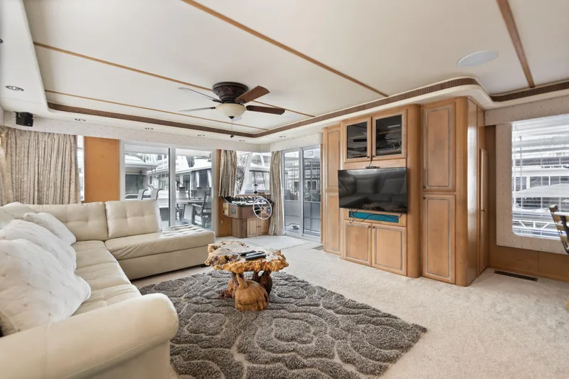 Slide: The Image of Luxurious 2001 Stardust Cruisers houseboat interior with plush seating and modern entertainment center. - 32