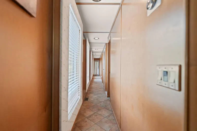Slide: The Image of Narrow hallway inside 2001 Stardust Cruisers 18 x 100 houseboat with wooden walls and tiled floor. - 39