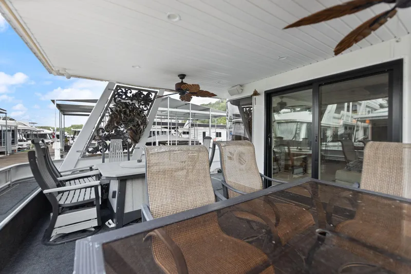 Slide: The Image of 2001 Stardust Cruisers houseboat deck with seating, glass table, and ceiling fans. - 4