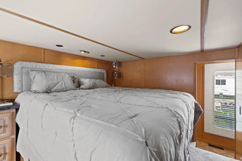 Slide: The Image of Cozy bedroom interior of 2001 Stardust Cruisers houseboat with plush bedding and wooden walls. - 40