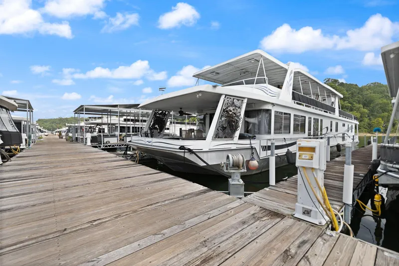 Slide: The Image of 2001 Stardust Cruisers 18 x 100 houseboat docked at a marina under a clear blue sky. - 5