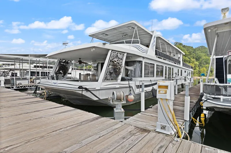 Slide: The Image of 2001 Stardust Cruisers 18 x 100 houseboat docked at marina under blue sky. - 6