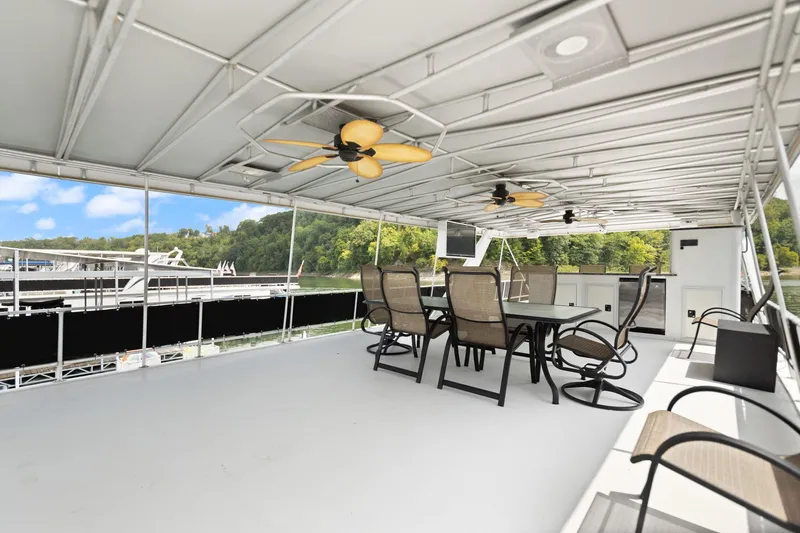 Slide: The Image of Spacious upper deck of 2001 Stardust Cruisers houseboat with seating and ceiling fans. - 8