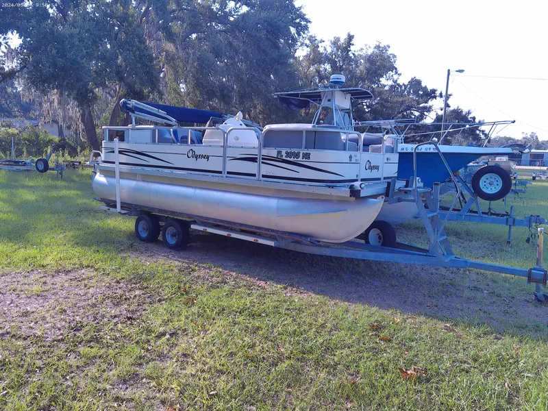 Slide: The Image of 2006 Odyssey Pontoons 218 DLX on trailer, parked on grassy area. - 1