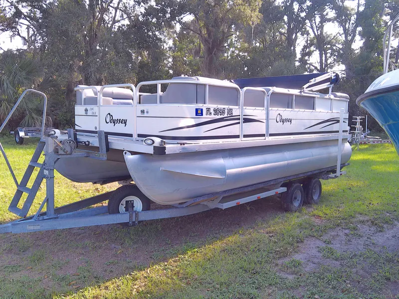 Slide: The Image of 2006 Odyssey Pontoons 218 DLX on trailer, parked on grass with trees in background. - 9
