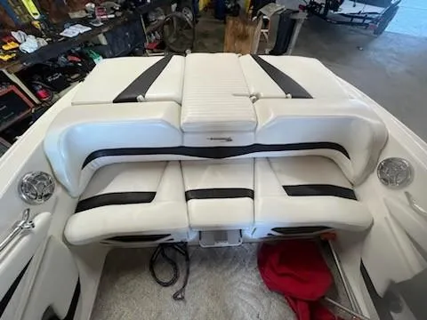 Slide: The Image of 2009 Glastron GT205 boat interior with white and black seating in a garage. - 7