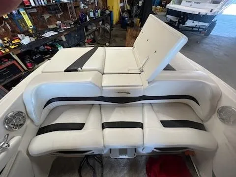 Slide: The Image of 2009 Glastron GT205 boat interior with white and black seating in a garage setting. - 8