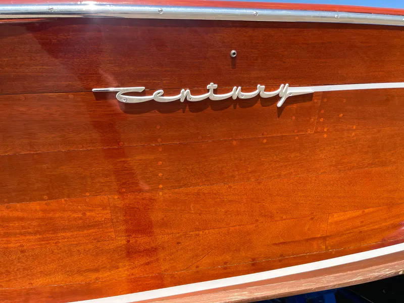Slide: The Image of 1966 Century Resorter boat with polished wood finish and chrome logo detail. - 12