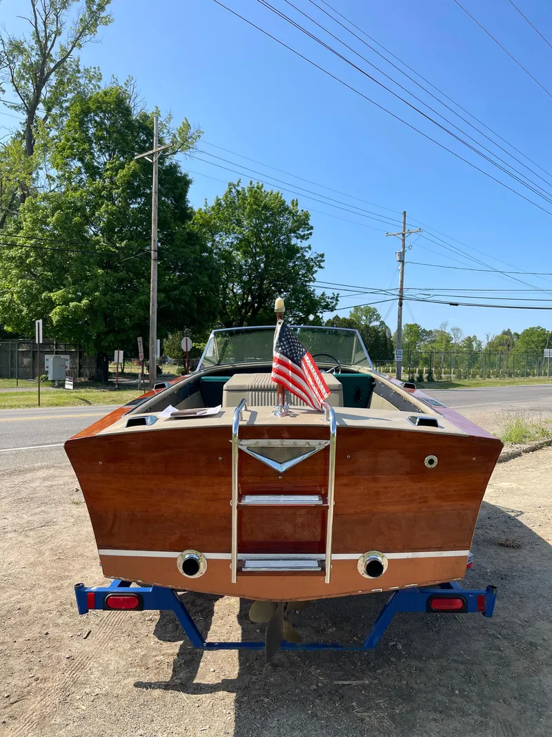 Slide: The Image of 1966 Century Resorter boat with wooden finish and American flag, parked outdoors. - 13