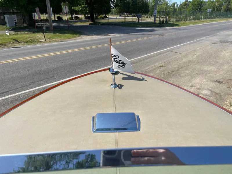 Slide: The Image of 1966 Century Resorter boat with flag, parked near a road on a sunny day. - 19