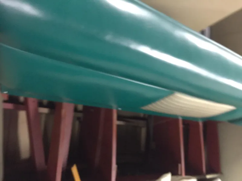 Slide: The Image of 1966 Century Resorter boat with teal hull, stored indoors. - 6