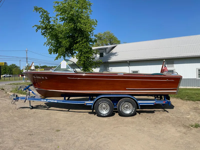 Slide: The Image of 1966 Century Resorter boat on trailer, wooden finish, parked outdoors. - 9