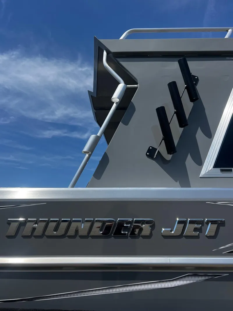 Slide: The Image of 2024 Thunder Jet 24 Alexis Pro boat with sleek metallic design under a clear blue sky. - 7