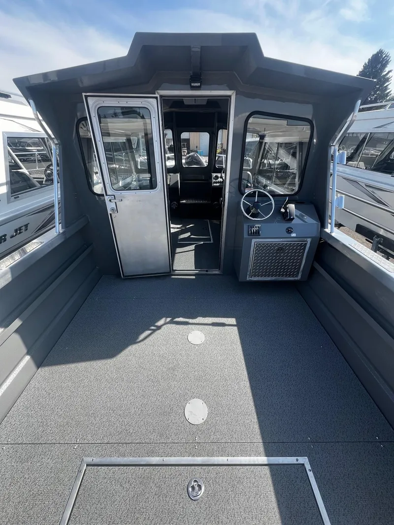 Slide: The Image of 2024 Thunder Jet 24 Alexis Pro boat interior with steering wheel and spacious deck. - 8
