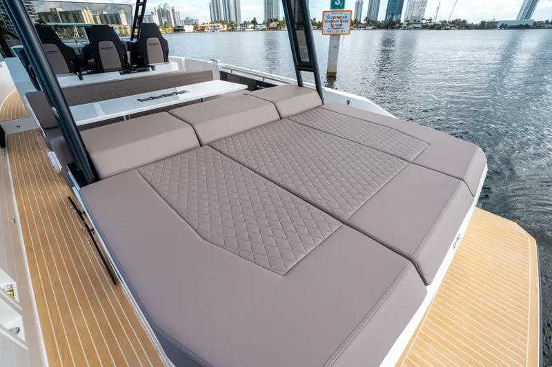 Slide: The Image of 2025 De Antonio Yachts D32 OPEN with spacious sunbed, docked by waterfront. - 10