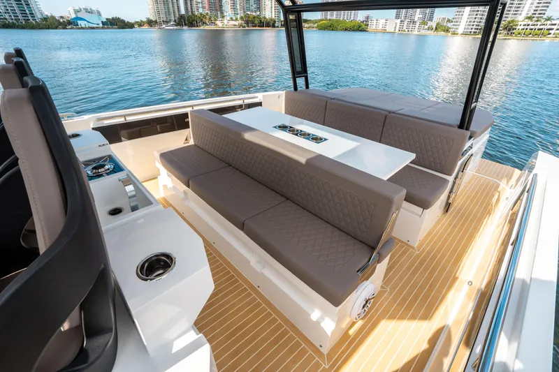 Slide: The Image of 2025 De Antonio Yachts D32 OPEN luxury seating area on deck, overlooking serene waterfront. - 22