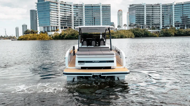 Slide: The Image of 2025 De Antonio Yachts D32 OPEN on water, city skyline in background. - 3