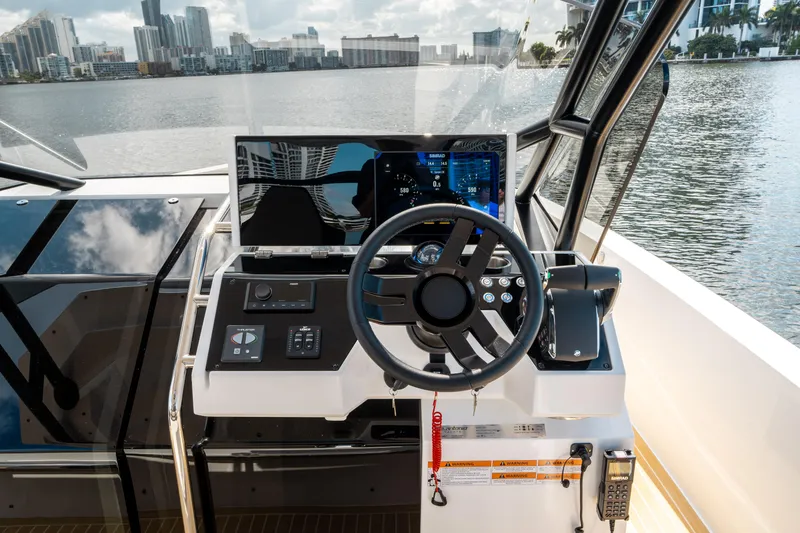 Slide: The Image of Helm of 2025 De Antonio Yachts D32 OPEN with city skyline in background. - 30