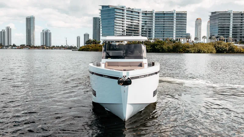 Slide: The Image of 2025 De Antonio Yachts D32 OPEN on water, city skyline in background. - 7