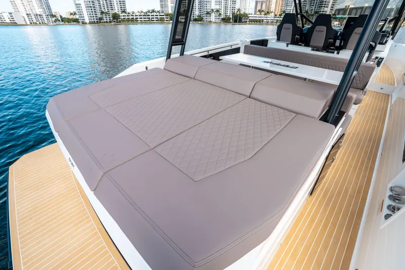 Slide: The Image of 2025 De Antonio Yachts D32 OPEN with spacious sunbed on deck, docked by waterfront. - 9