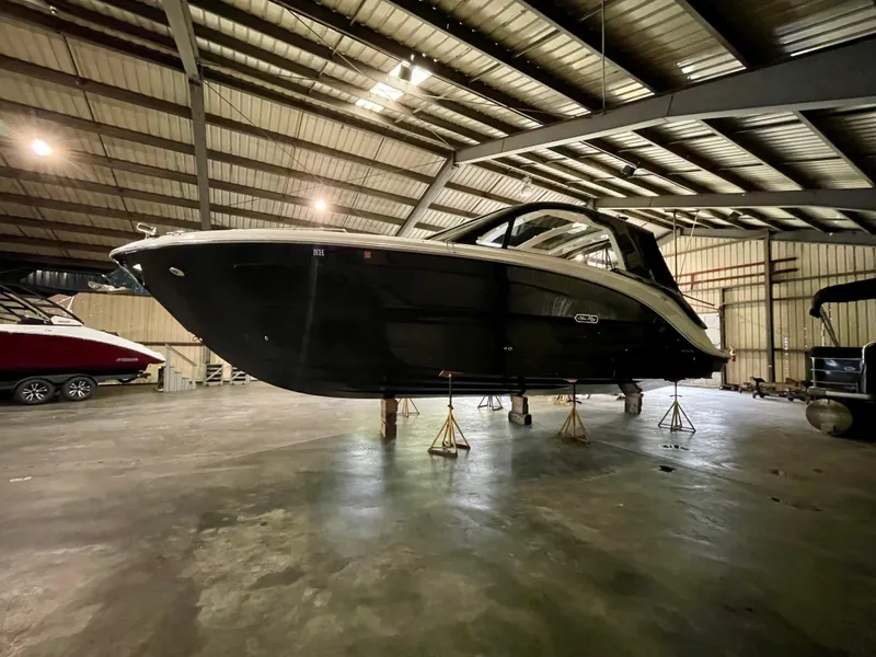 Slide: The Image of 2023 Sea Ray Sundancer 370 OB boat in a spacious indoor storage facility. - 11