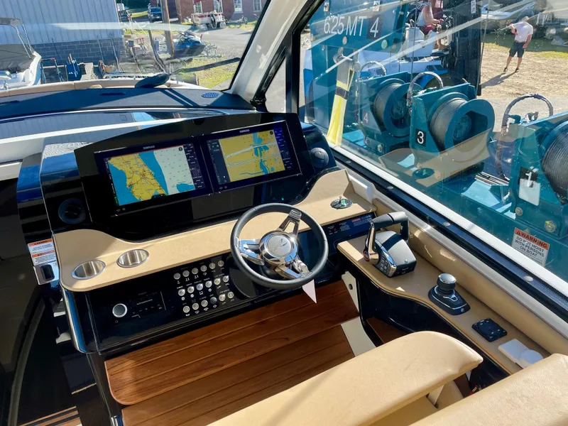 Slide: The Image of 2023 Sea Ray Sundancer 370 OB helm with advanced navigation displays and controls. - 13