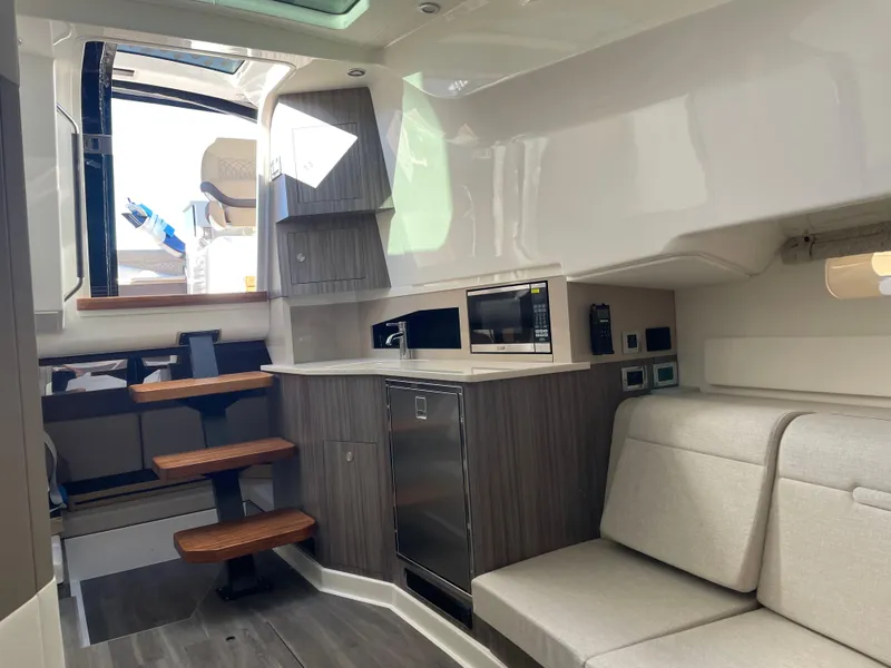 Slide: The Image of Interior of 2023 Sea Ray Sundancer 370 OB, featuring modern kitchen and seating area. - 17
