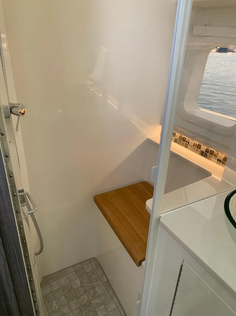 Slide: The Image of 2023 Sea Ray Sundancer 370 OB bathroom with shower and wooden seat. - 22