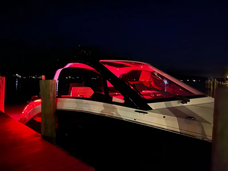 Slide: The Image of 2023 Sea Ray Sundancer 370 OB illuminated with red lights at night, docked by the water. - 3