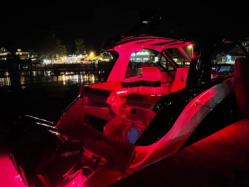 Slide: The Image of 2023 Sea Ray Sundancer 370 OB illuminated at night with vibrant red lighting. - 5