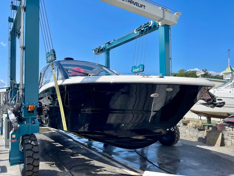 Slide: The Image of 2023 Sea Ray Sundancer 370 OB yacht in a boat lift under clear blue sky. - 6