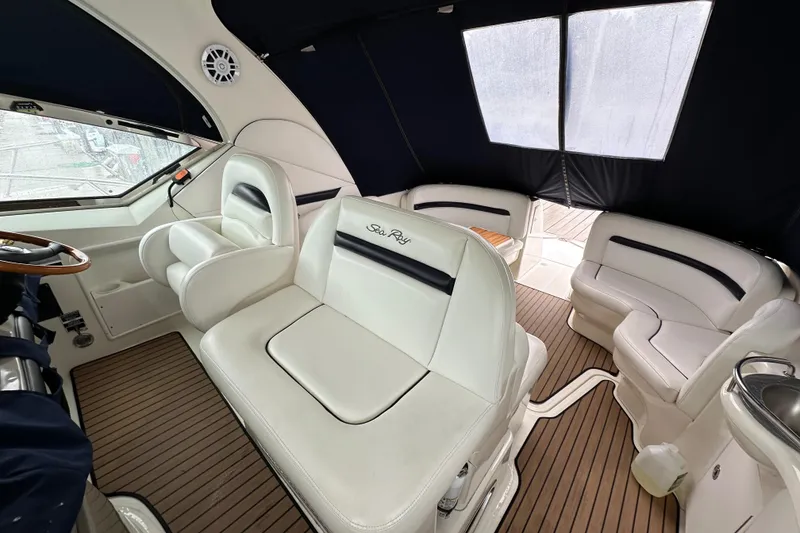 Slide: The Image of 2006 Sea Ray 38 Sundancer interior with white seating and wood flooring. - 32
