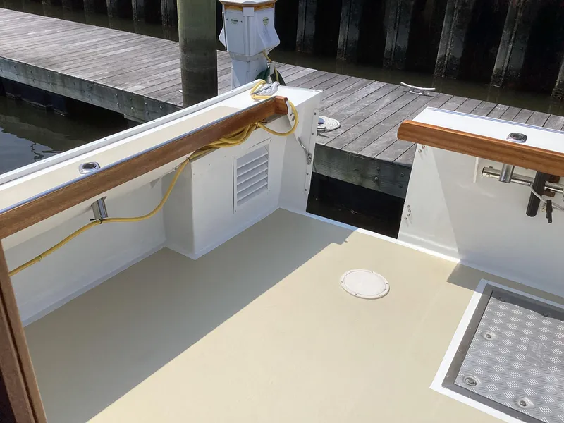 Slide: The Image of Willis Beal 35 Extended Pilothouse 2021 boat deck with wooden railings and dock view. - 10