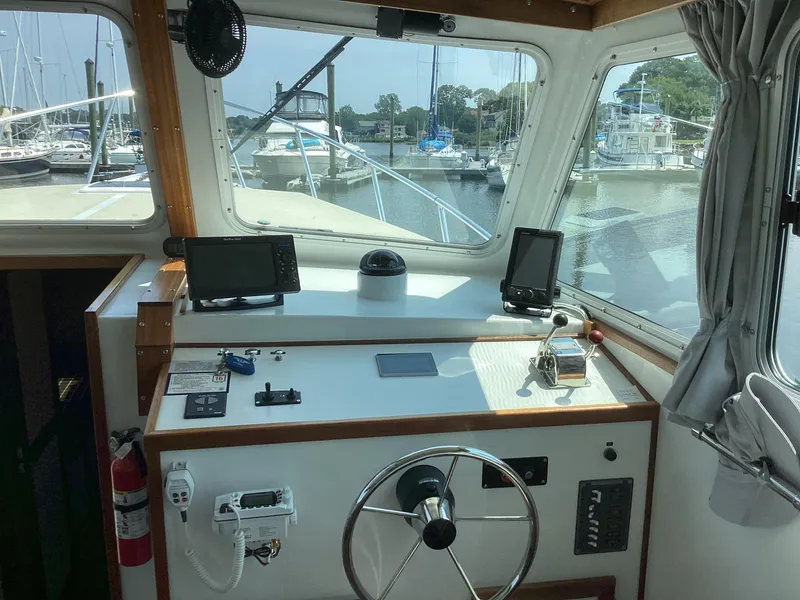 Slide: The Image of Pilothouse interior of 2021 Willis Beal 35 Extended, featuring navigation equipment and marina view. - 28