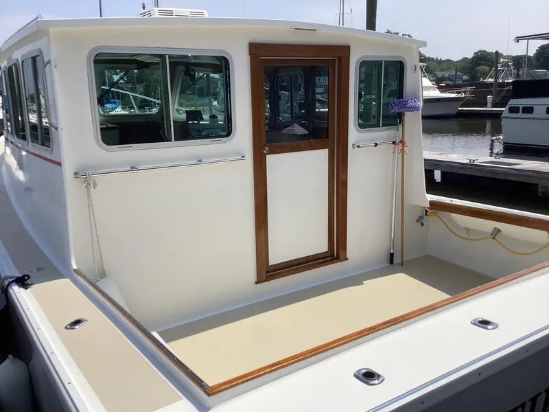 Slide: The Image of Willis Beal 35 Extended Pilothouse 2021, docked, showcasing rear deck and pilothouse entrance. - 7