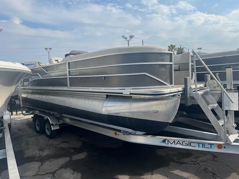The Image of 2022 Cypress Cay Seabreeze 232 pontoon boat on trailer under cloudy sky. - 0