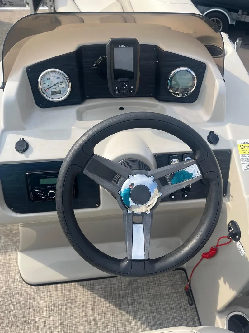 Slide: The Image of 2022 Cypress Cay Seabreeze 232 boat dashboard with steering wheel and gauges. - 5
