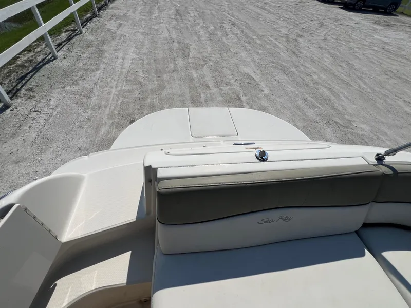 Slide: The Image of 2006 Sea Ray 240 Sundeck boat interior with seating, parked on gravel. - 11
