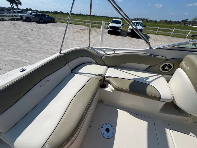 Slide: The Image of 2006 Sea Ray 240 Sundeck interior with beige seating and open deck view. - 14