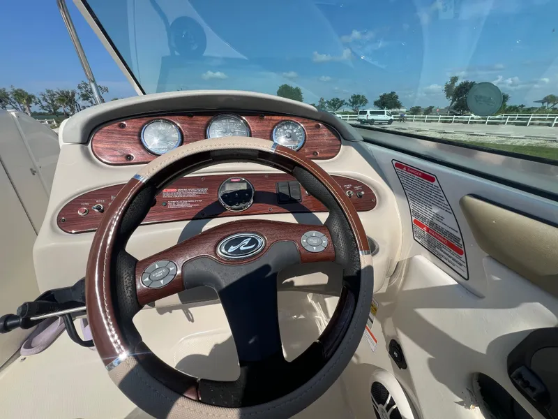 Slide: The Image of 2006 Sea Ray 240 Sundeck dashboard with steering wheel and gauges. - 16