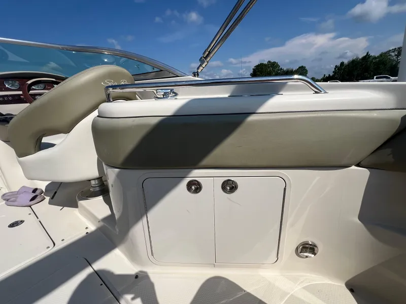 Slide: The Image of 2006 Sea Ray 240 Sundeck interior with seating and storage under clear blue sky. - 20