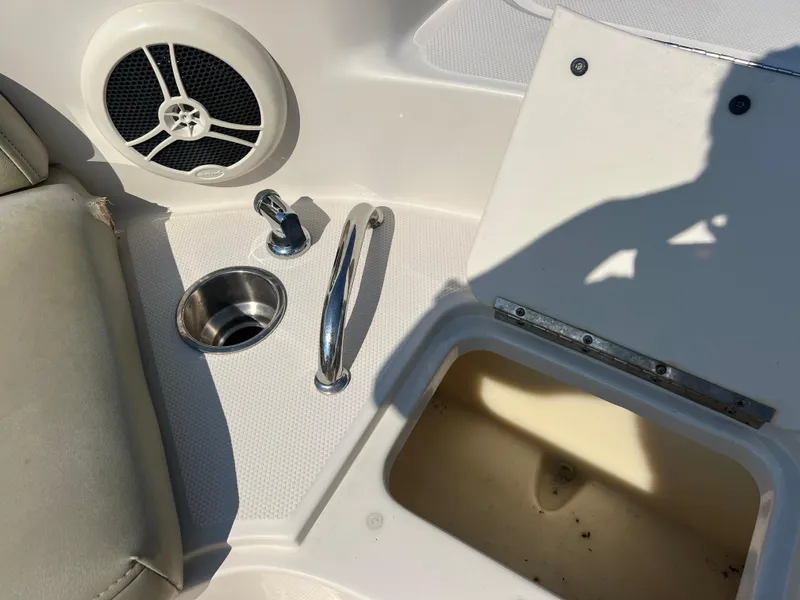 Slide: The Image of 2006 Sea Ray 240 Sundeck interior with speaker, cup holder, and storage compartment. - 22