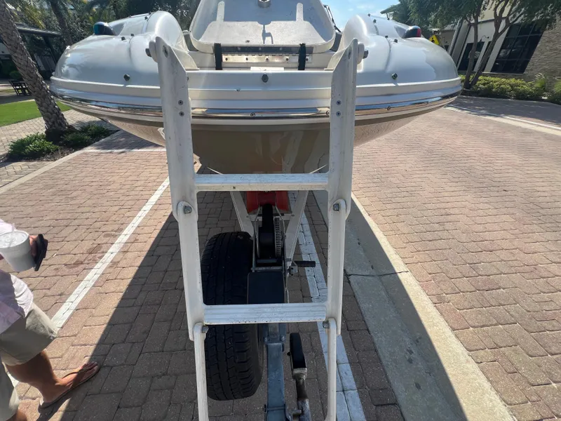 Slide: The Image of 2006 Sea Ray 240 Sundeck on trailer with ladder, parked on brick pavement. - 23