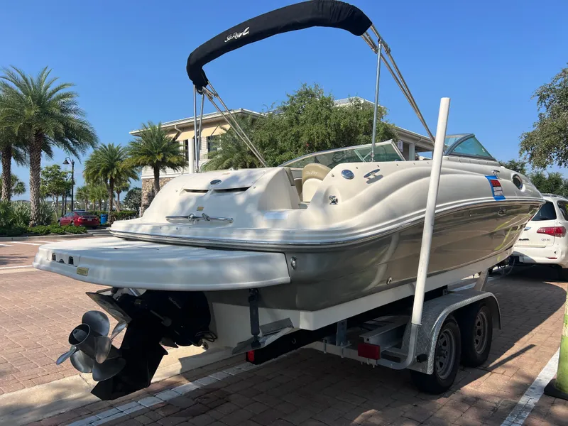Slide: The Image of 2006 Sea Ray 240 Sundeck boat on trailer, parked near palm trees. - 33