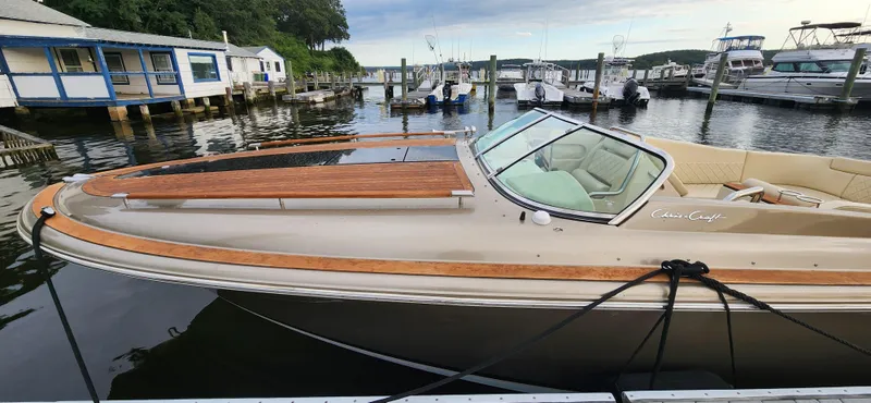 Slide: The Image of 2017 Chris-Craft Corsair 32 docked at a marina, showcasing elegant design and wooden accents. - 13