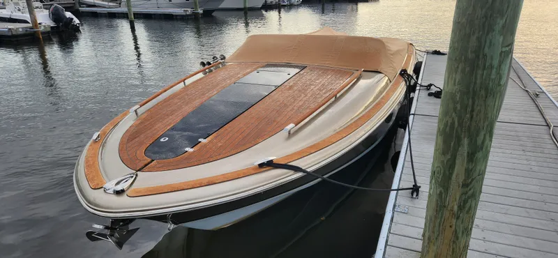 Slide: The Image of 2017 Chris-Craft Corsair 32 docked, featuring elegant wood deck and sleek design. - 16