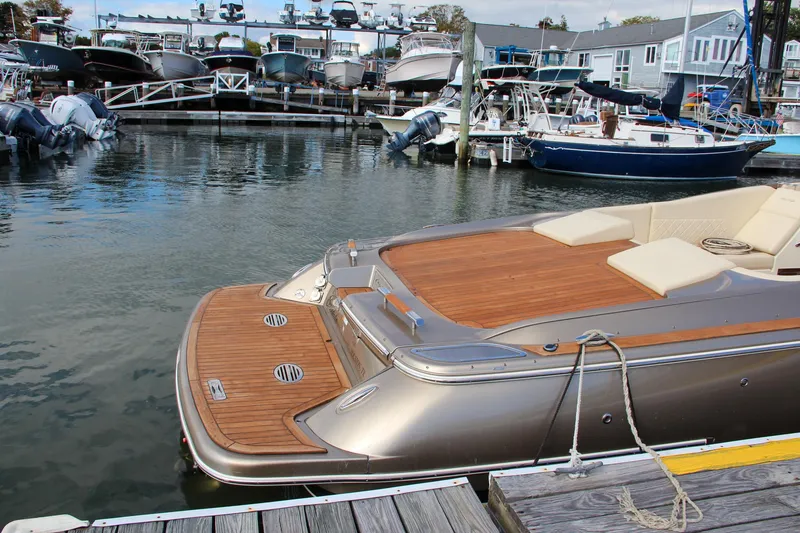 Slide: The Image of 2017 Chris-Craft Corsair 32 docked, featuring elegant teak decking and luxurious seating. - 17